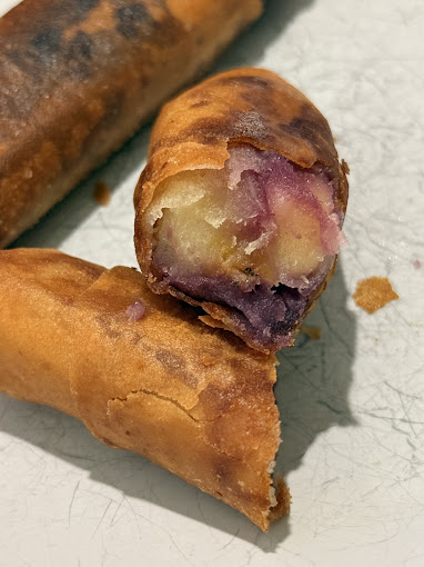 Fresh-fried turon, ube and banana, cut open to show the filling